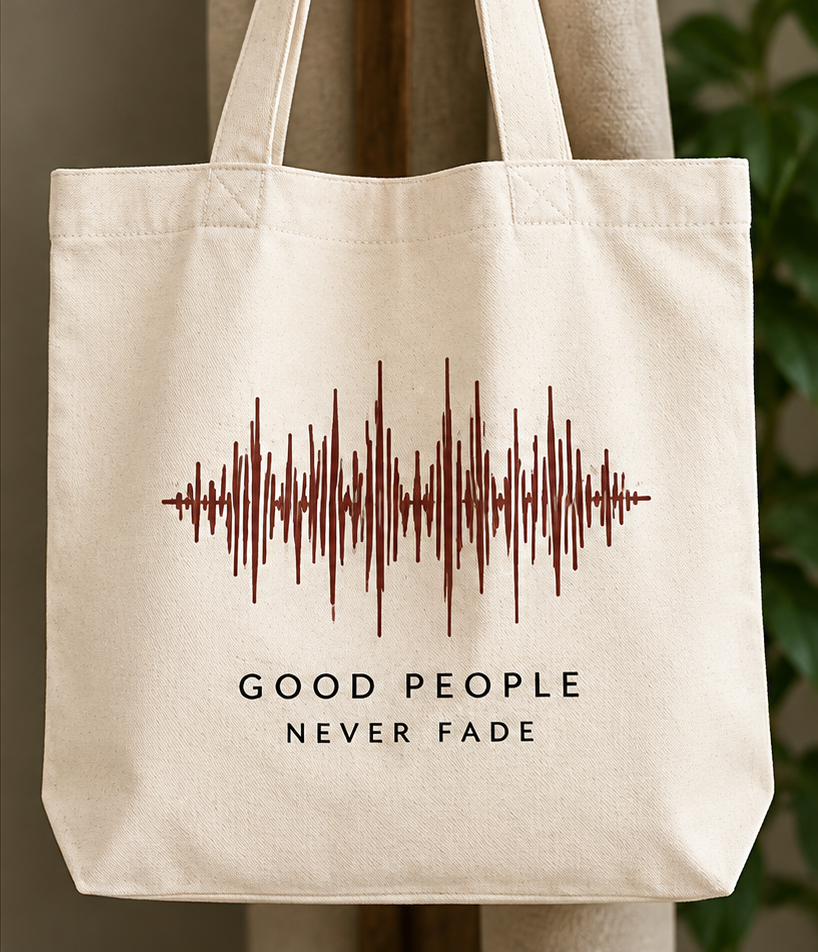 A canvas tote bag printed with a waveform above the words “Good people never fade”.