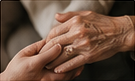 A young hand holding an elderly hand.